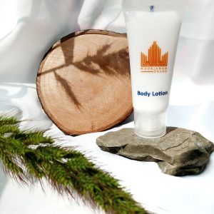 Home Body lotion displayed creatively with natural elements like wood and stone for skincare marketing.