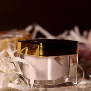 Home A close-up of a luxurious cream jar surrounded by elegant packaging materials.
