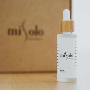 Home Close-up of a miSolo cosmetics serum bottle with minimalist design, perfect for skincare promotions.